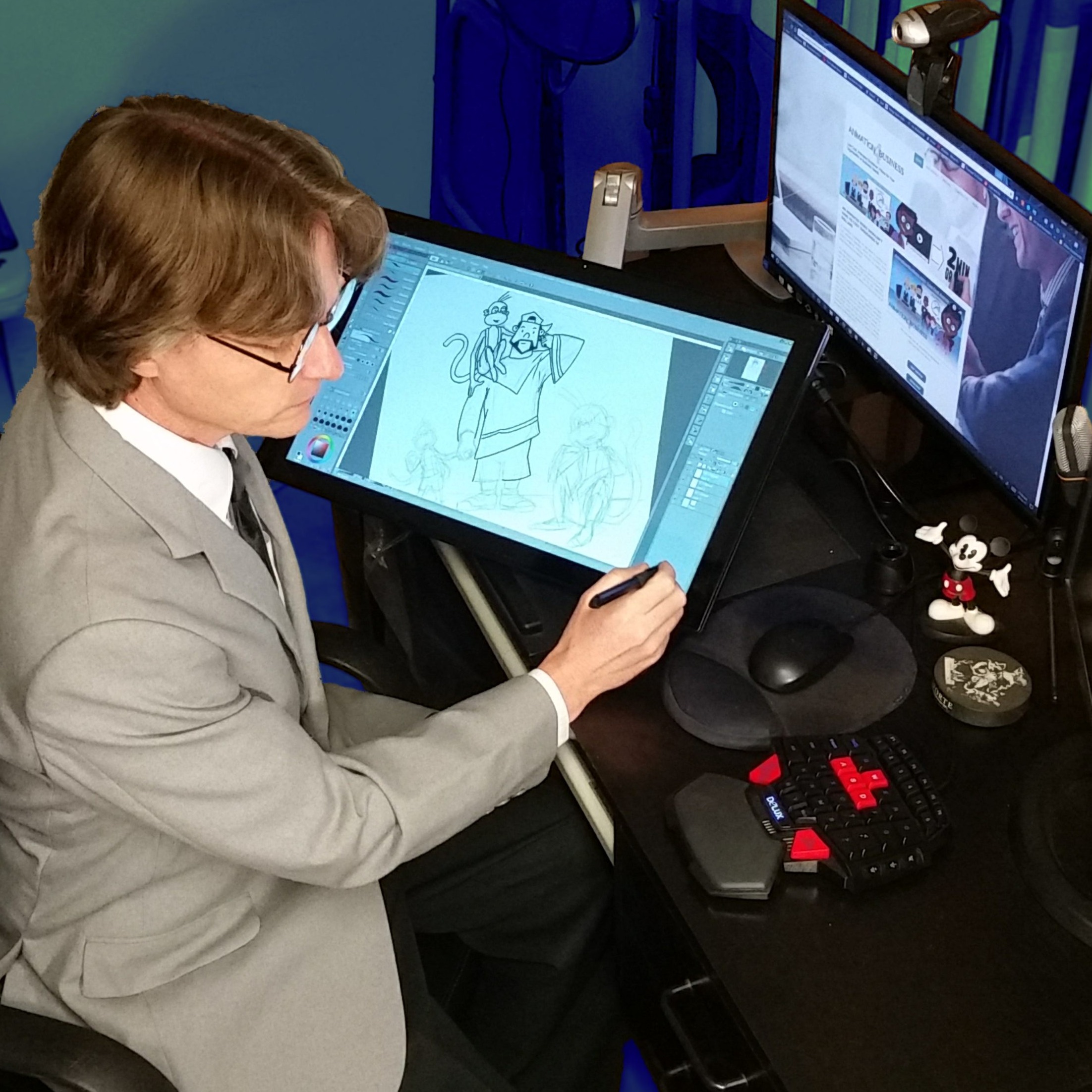 TET at his desk using a pen display tablet to draw cartoons.